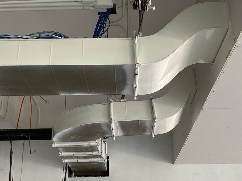 Ductwork for HVAC system installation with smooth white metal ducts and visible wiring, illustrating air conditioning and ventilation services by Dale-Air.